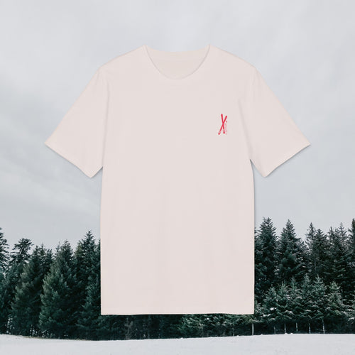 Naturweißes Shirt mit gekreuzten Skiern als zartem Brustprint, vor verschneitem Nadelwald